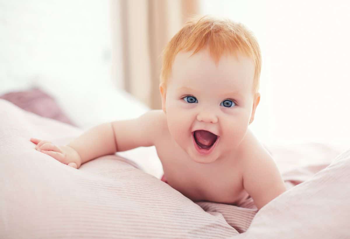 An adorable infant on a bed.