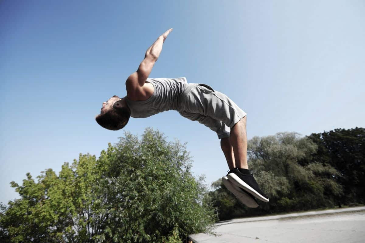 A young man doing a backflip.