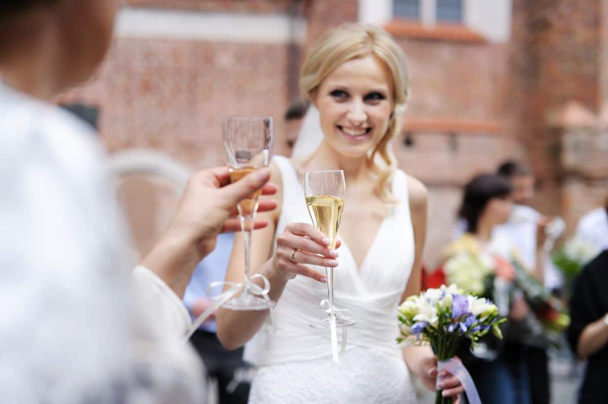 A bride holding a drink.
