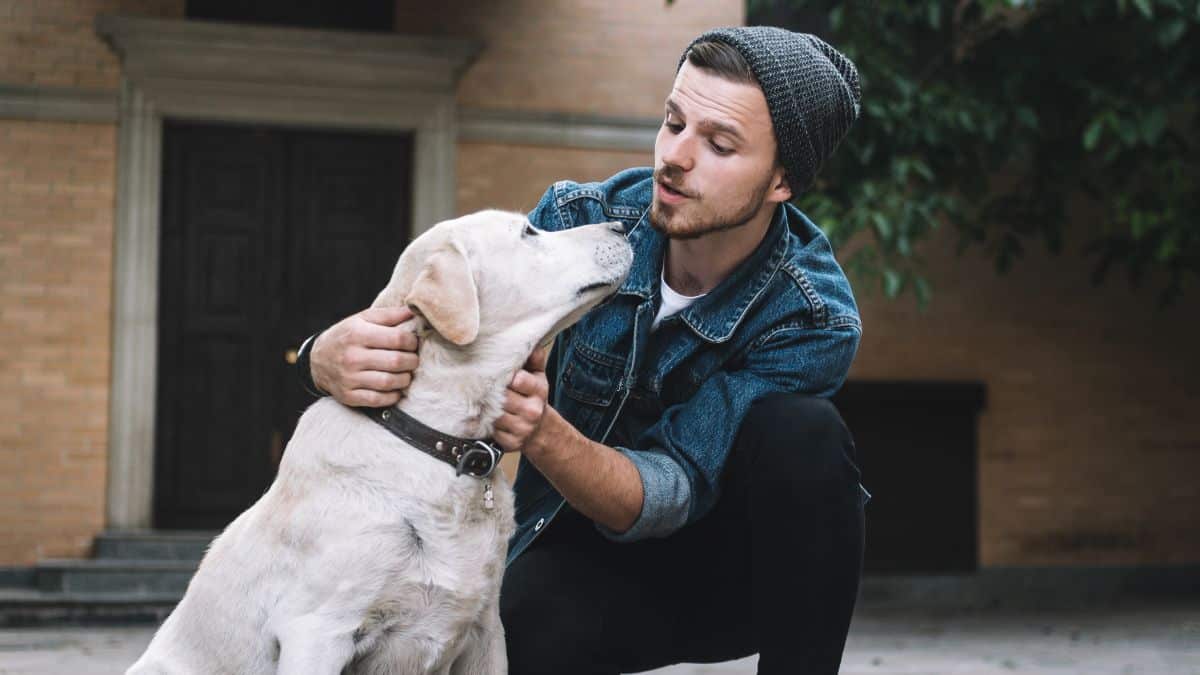 A young man talks to his dog.