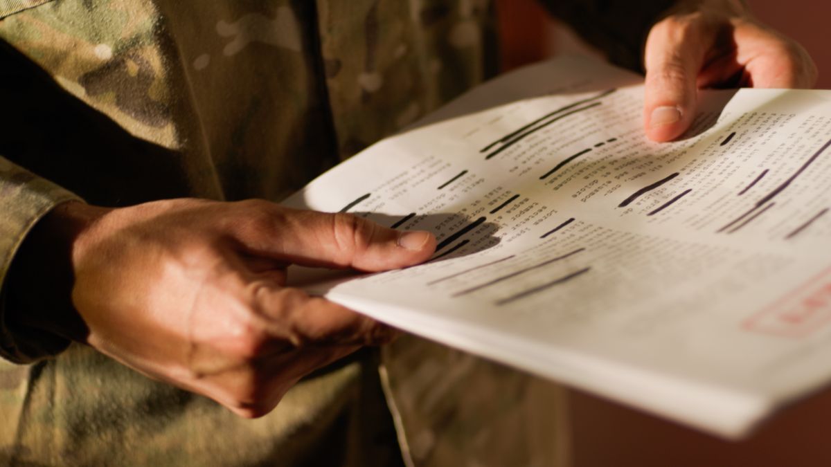 A soldier holds top-secret documents.