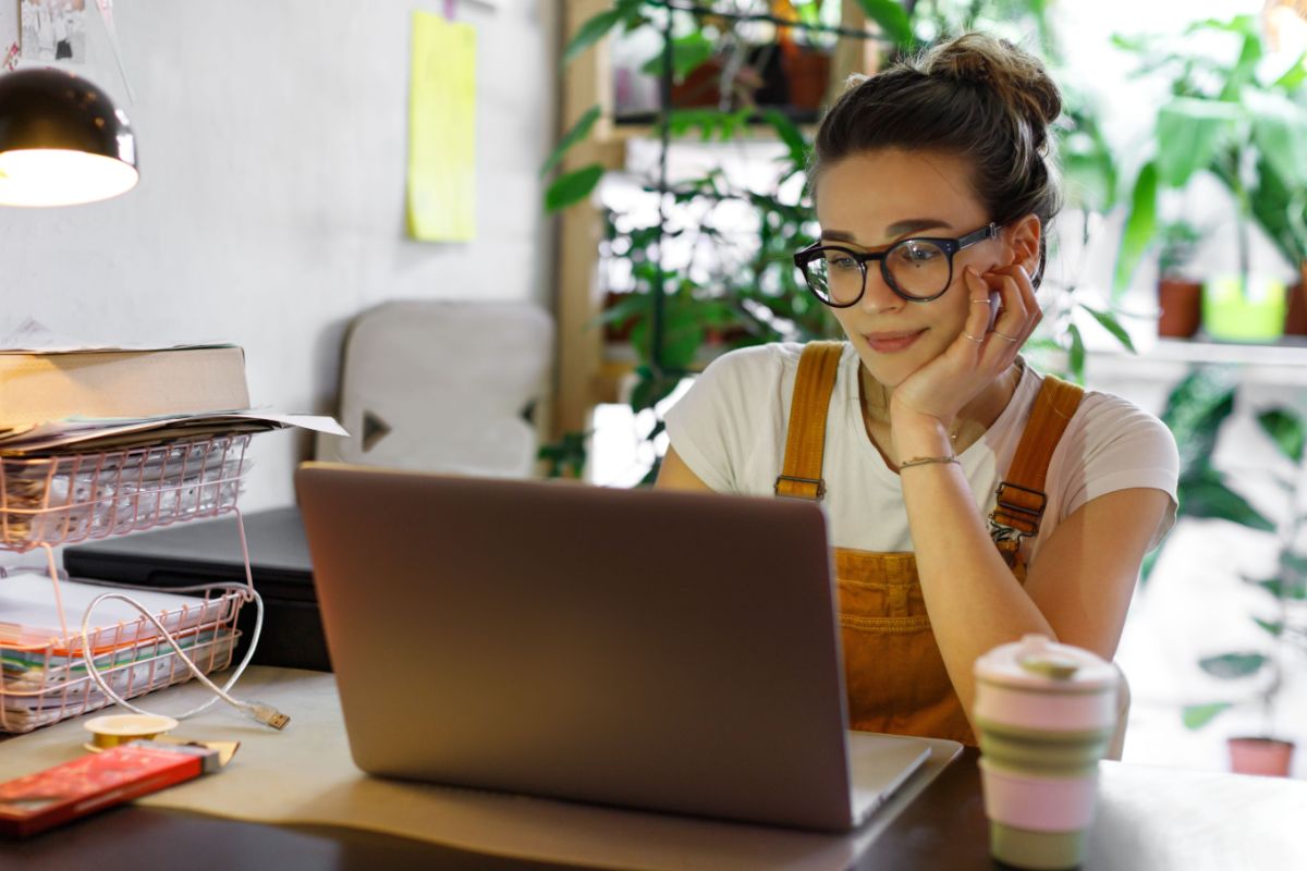 A young woman with glasses using a laptop.