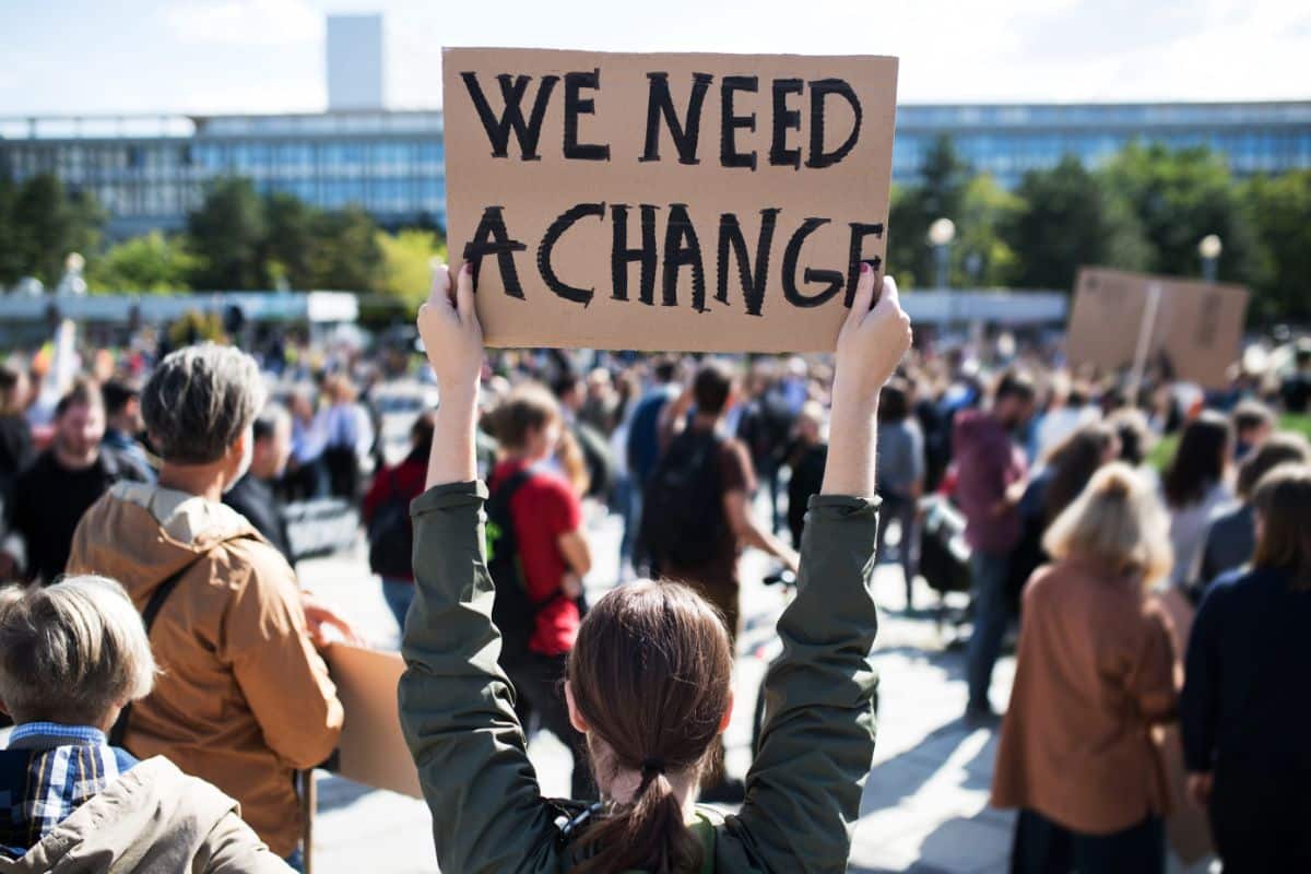 A protestor holds a sign - We need a change.