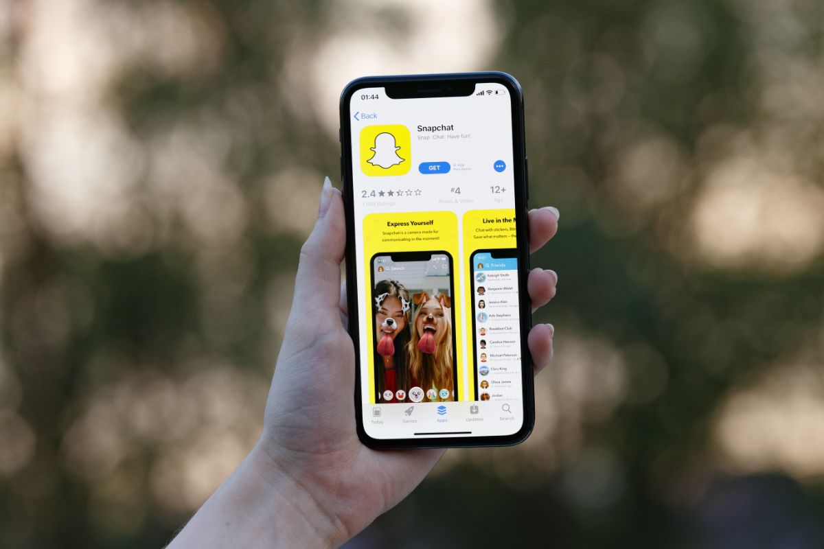 A hand holds a phone with a Snapchat app.