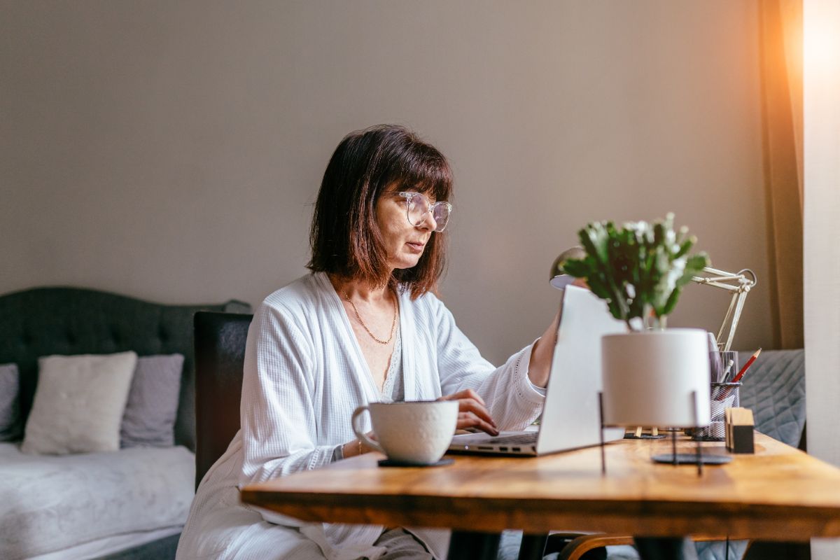 A senior woman searches on her laptop in the morning.